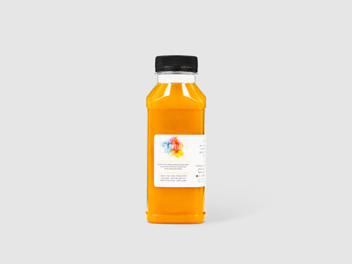 Turmeric broth smoothie bottle with amber orange liquid and black screw cap