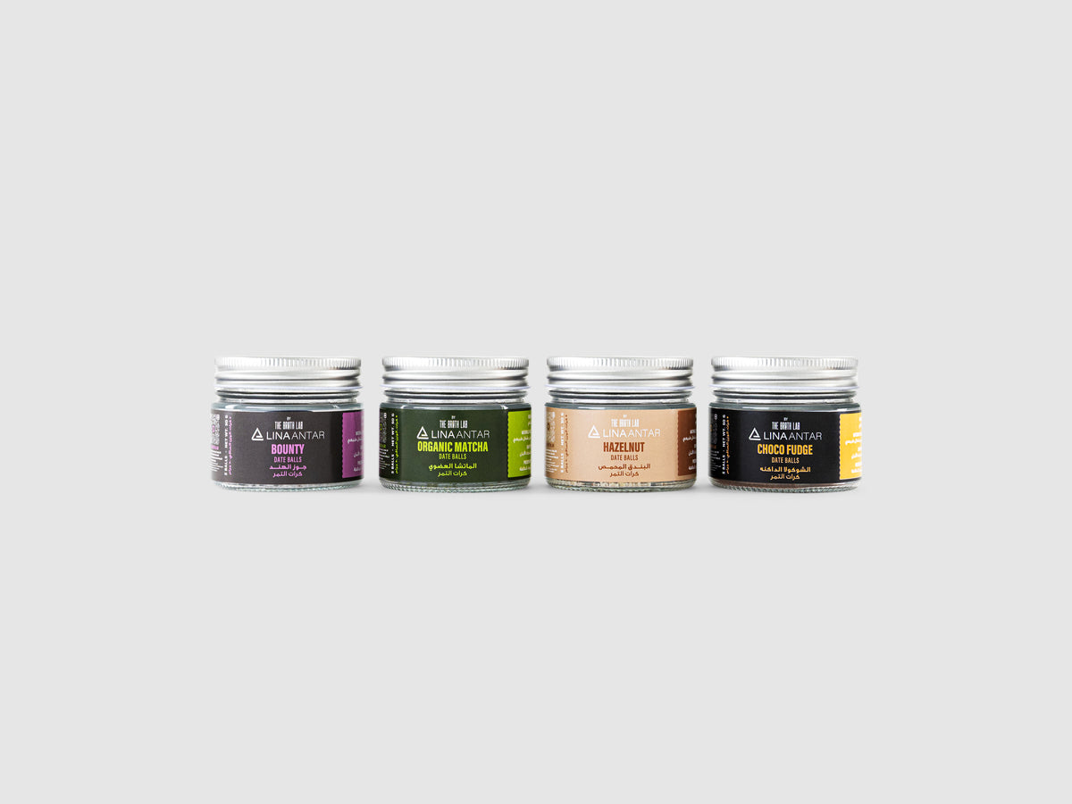 Wellness energy pack: four supplement jars with metal lids in purple, green, tan