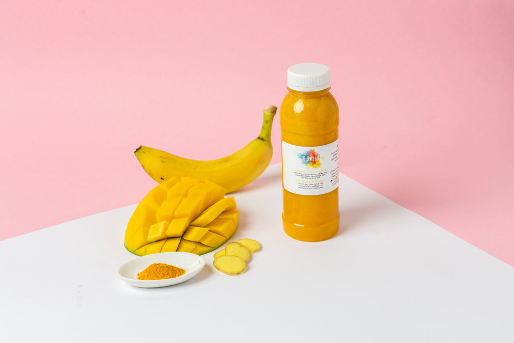 Turmeric broth smoothie bottle with turmeric powder and banana slices