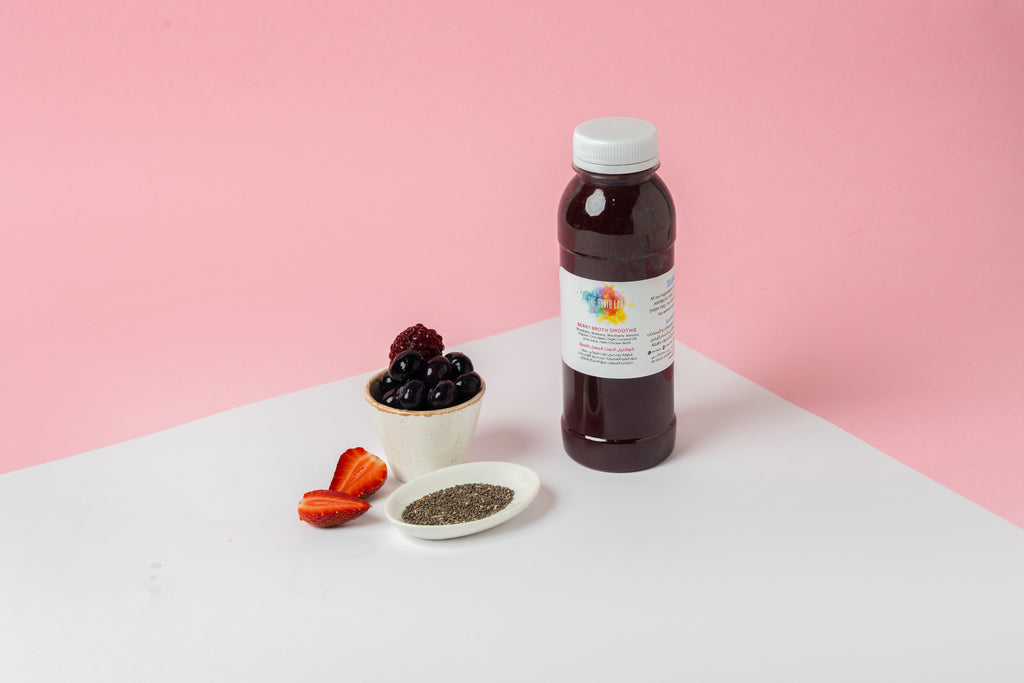 Berry smoothie bottle with white cap, shown with berries and small seeds
