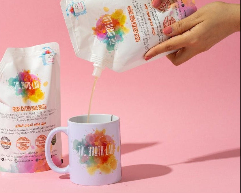 Person pouring a product from a bag into a mug on a pink background