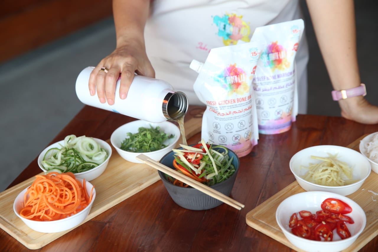 Ramen kit prep on a table with vegetable bowls, chopsticks, and broth pouches